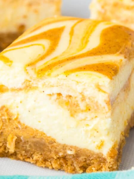 Close view of a pumpkin swirl cheesecake bar with a few more bars in the background.