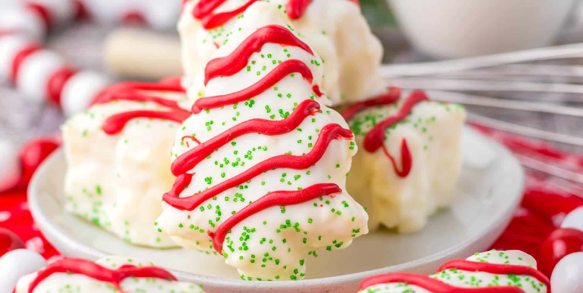 Close-up of white frosted Christmas tree-shaped cake decorated like a copy cat Little Debbie tree cake on a plate.