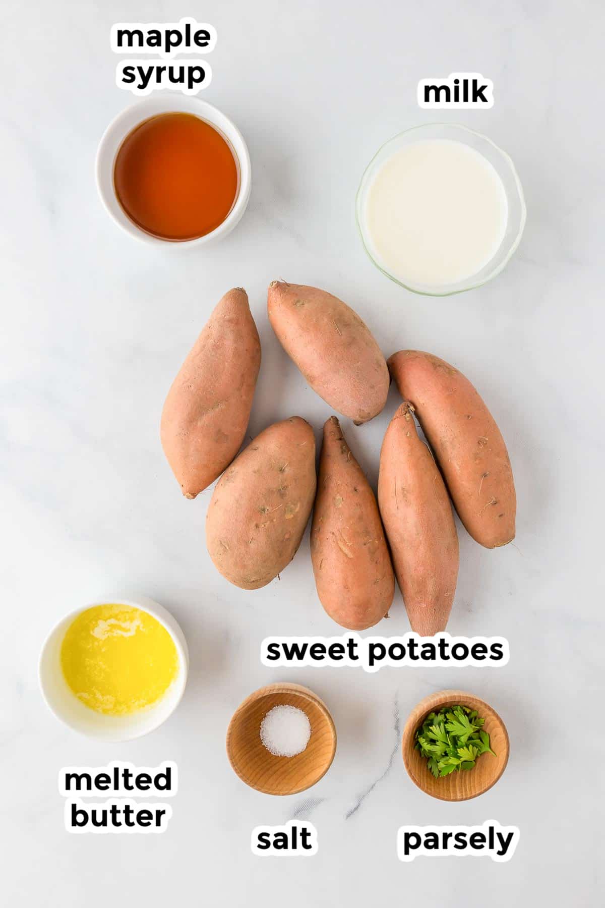 Ingredients for mashed sweet potatoes on a counter in bowls with text labels.