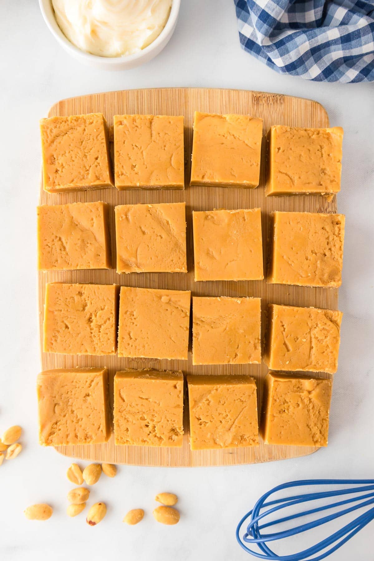 Squares of peanut butter fudge right after slicing on a cutting board from above.