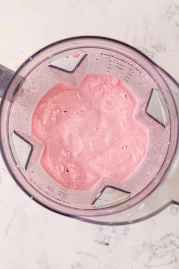 Pink peppermint milk shake after blending in a blender from overhead.