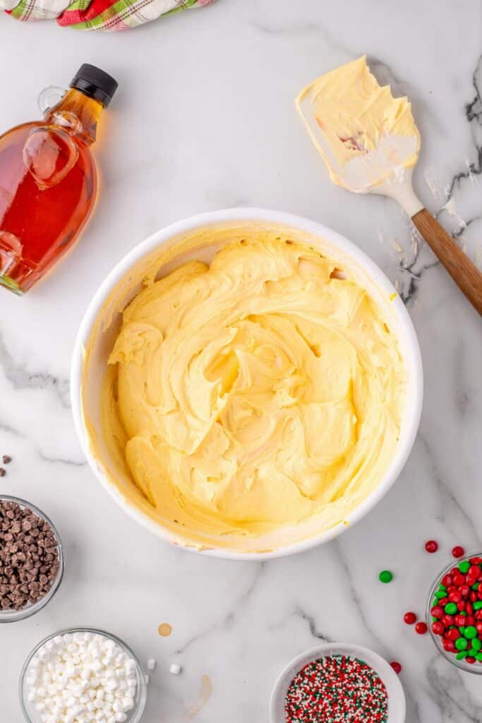 A bowl of yellow frosting for elf cupcakes after mixing in food coloring to make it a spaghetti color.