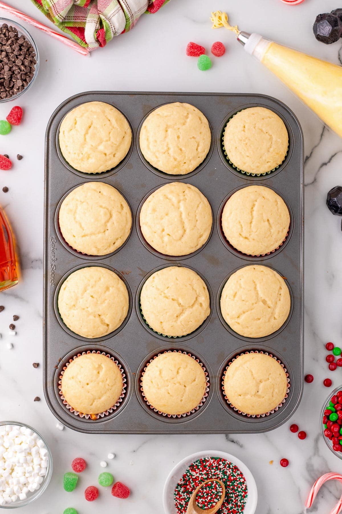 A muffin pan with twelve plain cupcakes or Elf cupcakes.