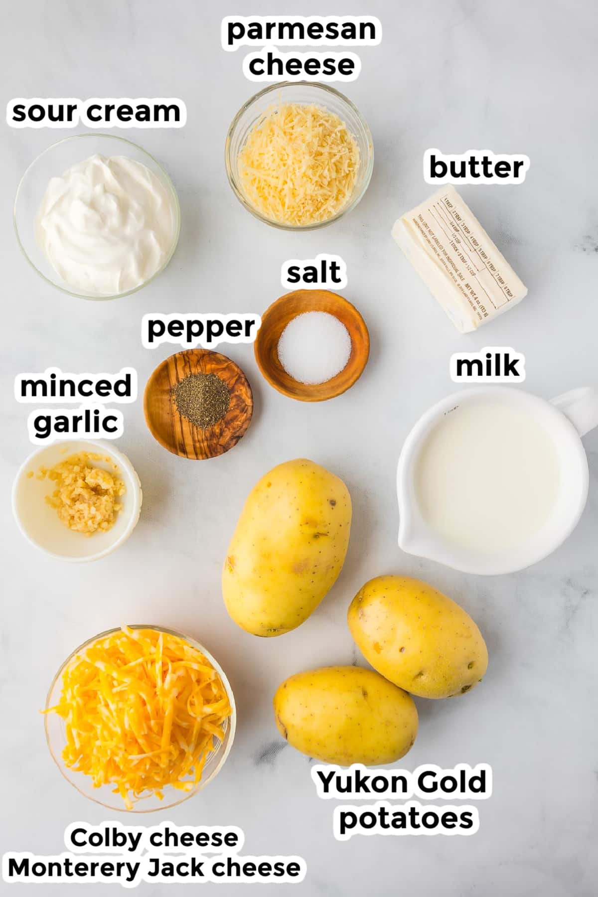 Ingredients for Yukon Gold mashed potatoes in bowls on a counter with text labels.