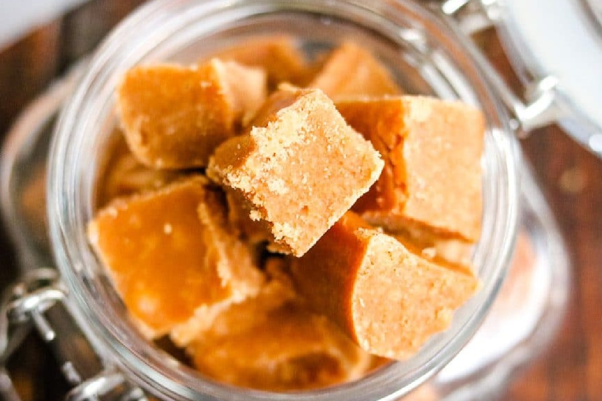 Glass jar from above filled with square pieces of caramel fudge.