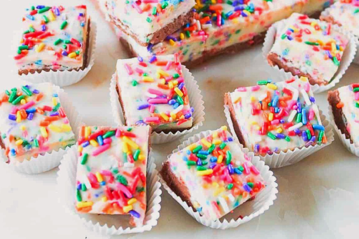 Colorful funfetti sprinkle fudge cut in pieces in cupcake liners.