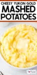 Tall image of Yukon gold mashed potatoes in a bowl with melty butter with title text across the top of the image.