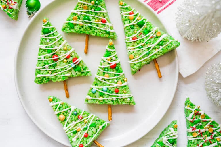 Rice Krispie treats shaped like Christmas trees on a plate.