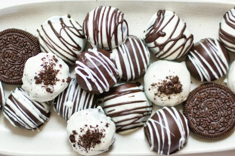 A plate of decorated chocolate truffles from above.