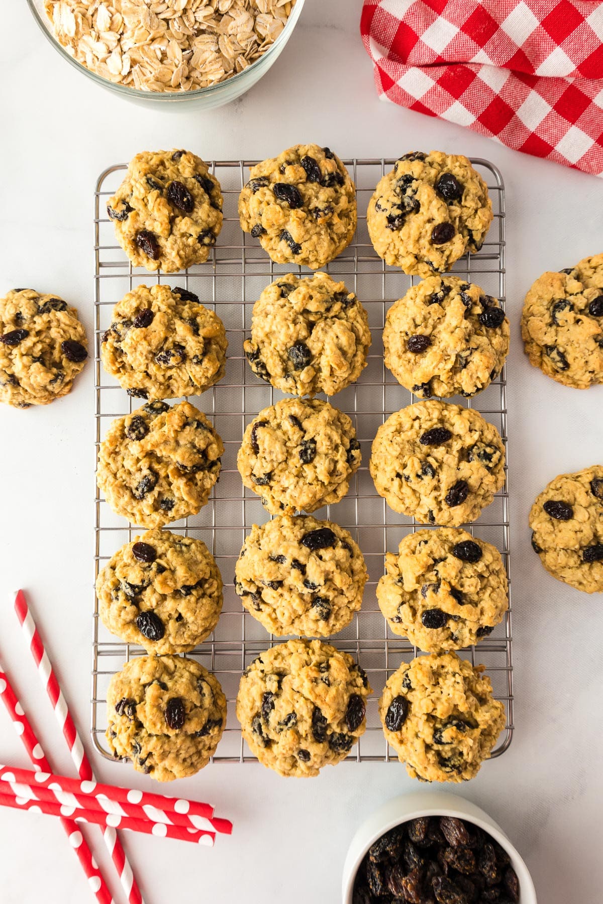 Oatmeal raisin cookies cooling on a wire cooling rack on a counter.