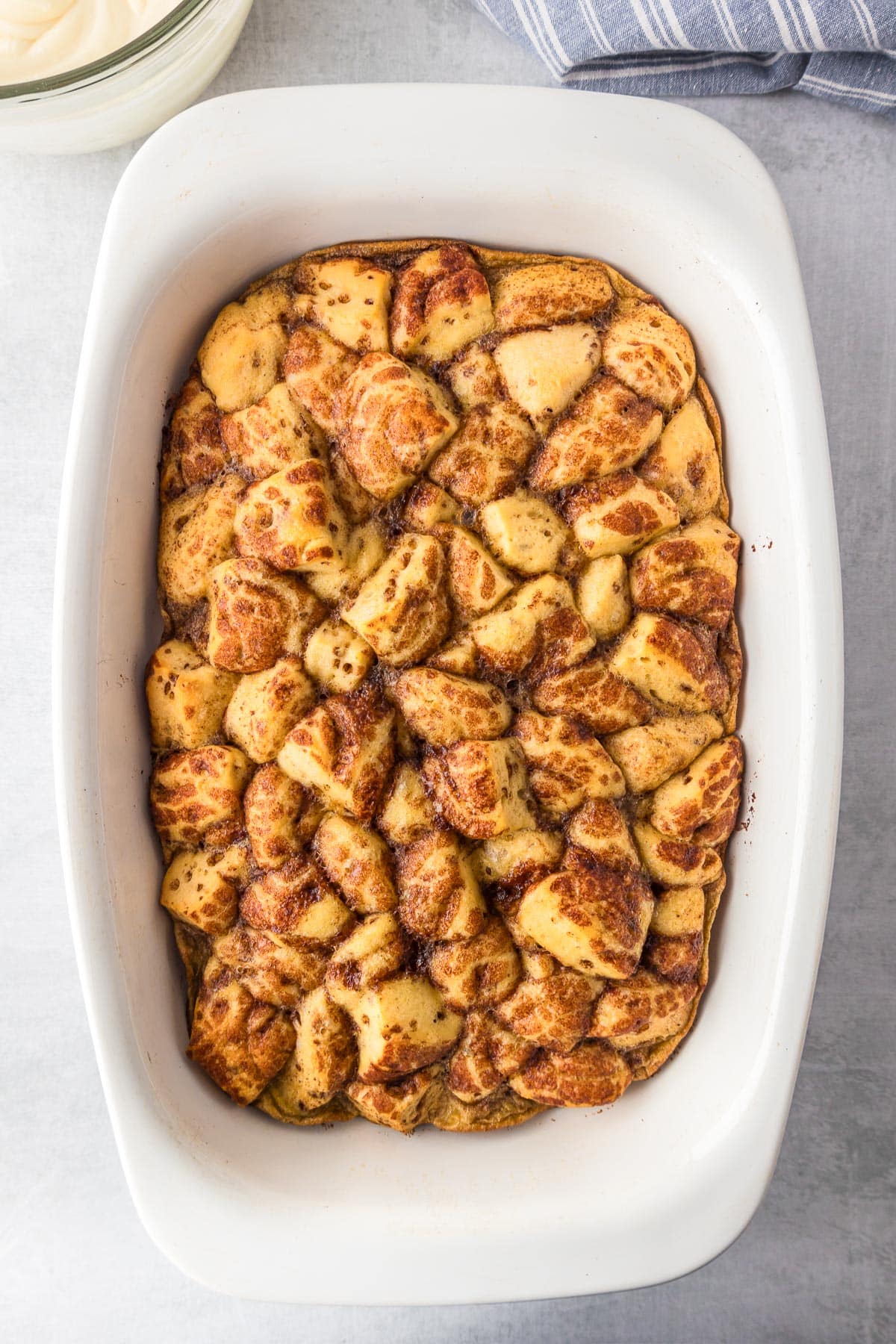 Cinnamon roll casserole after baking to a golden brown in a baking pan from overhead.