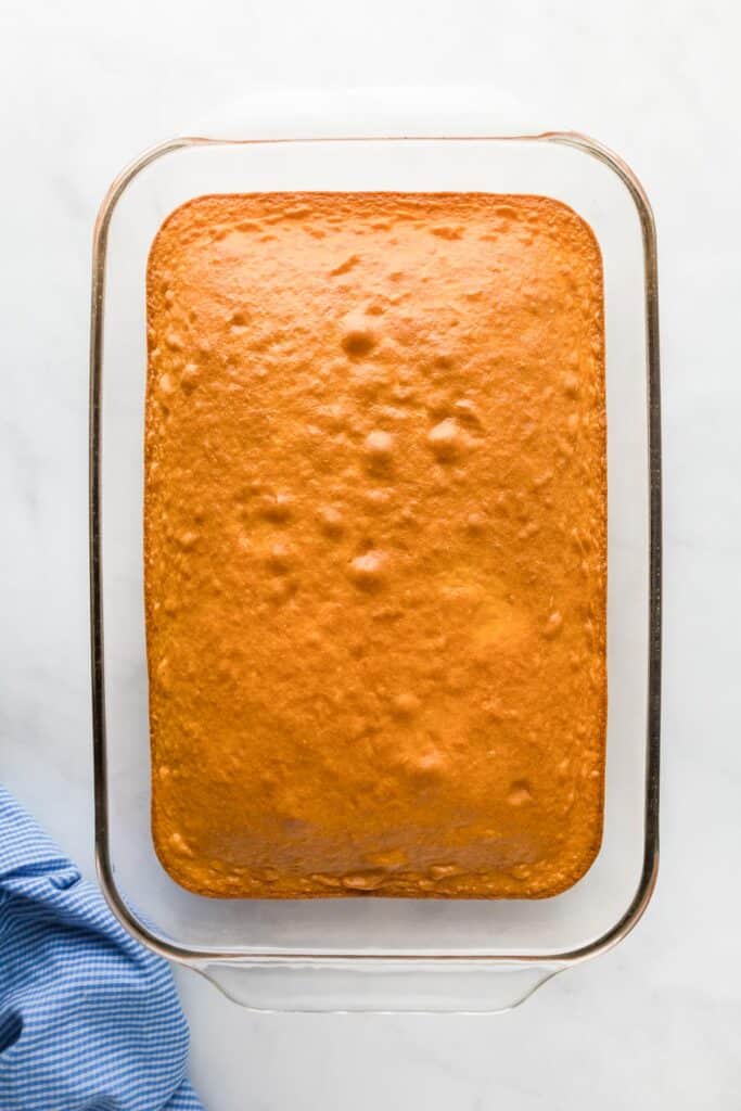 A yellow cake baked in a glass rectangular casserole dish for banana pudding poke cake.