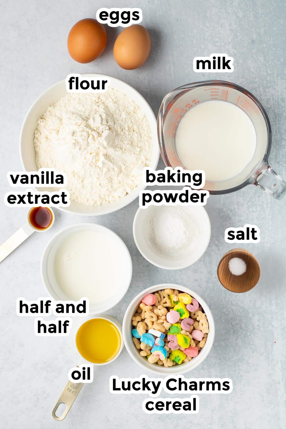 Ingredients for Lucky Charms pancakes in bowls on a kitchen counter with text labels.