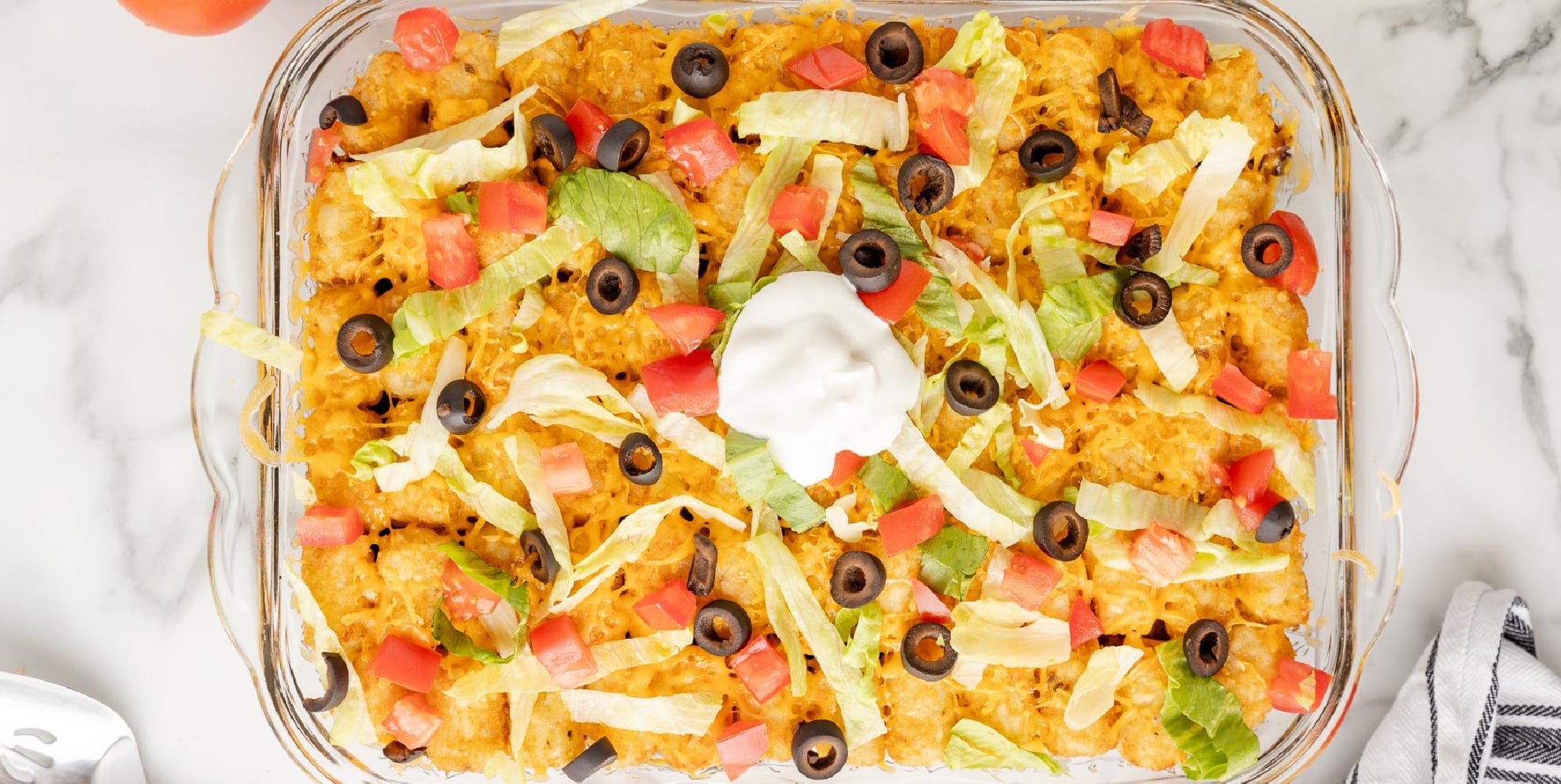 A wide view of a casserole dish with a layered taco tater tot casserole from above on a counter