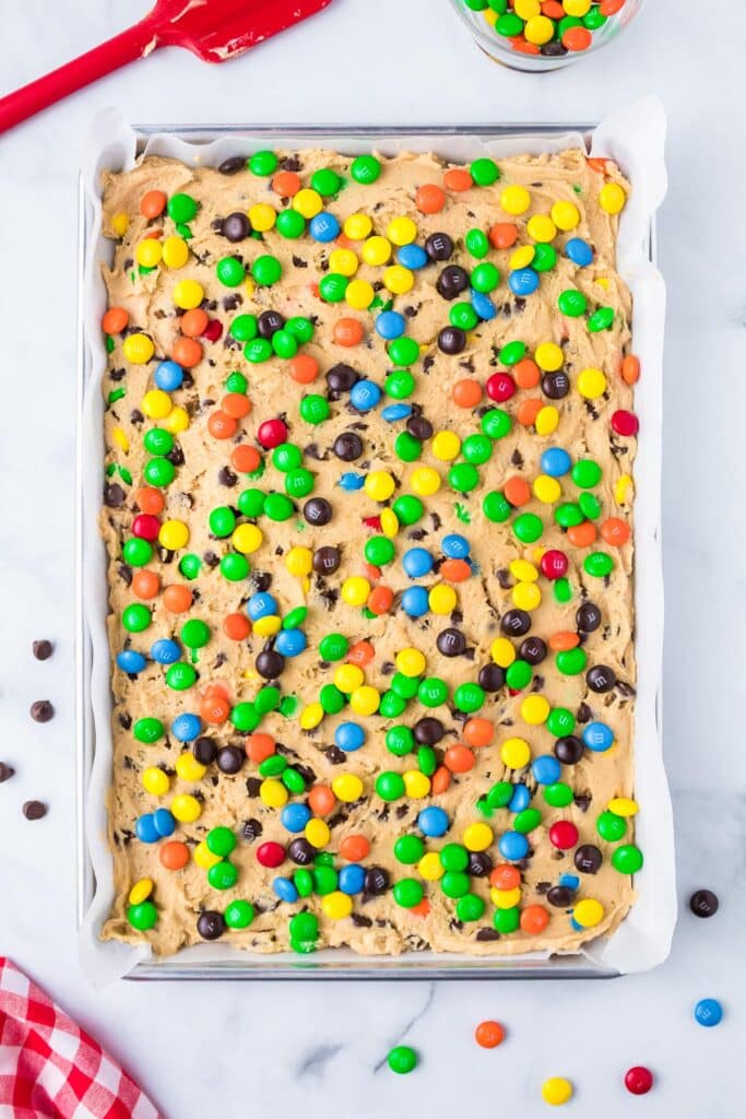 Baking tray with cookie dough topped with M&Ms before baking.