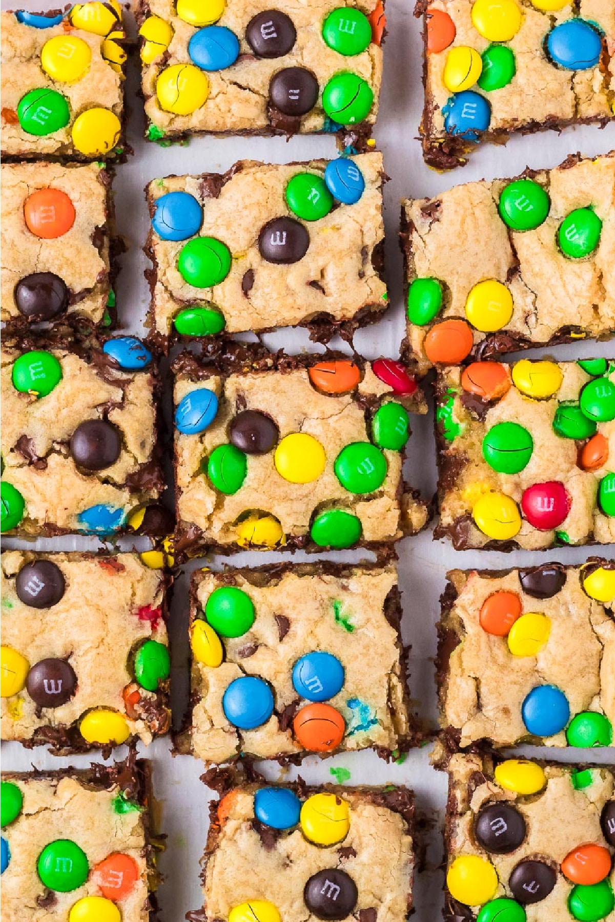 M&M cookie bars topped with colorful M&Ms after slicing in rows from above.