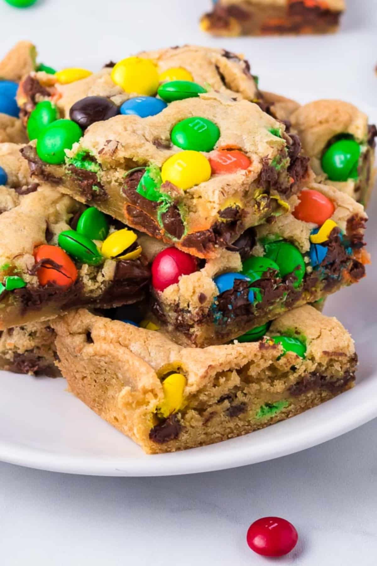 A plate of cookie bars topped with colorful candy-coated chocolates.