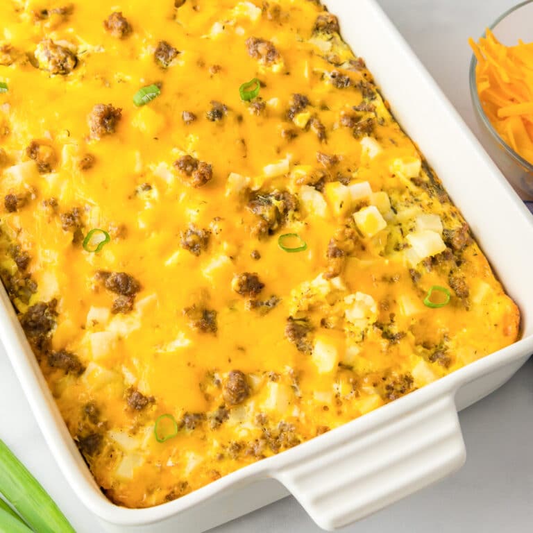 Square view of a casserole dish with sausage potato breakfast casserole topped with cheese after baking.