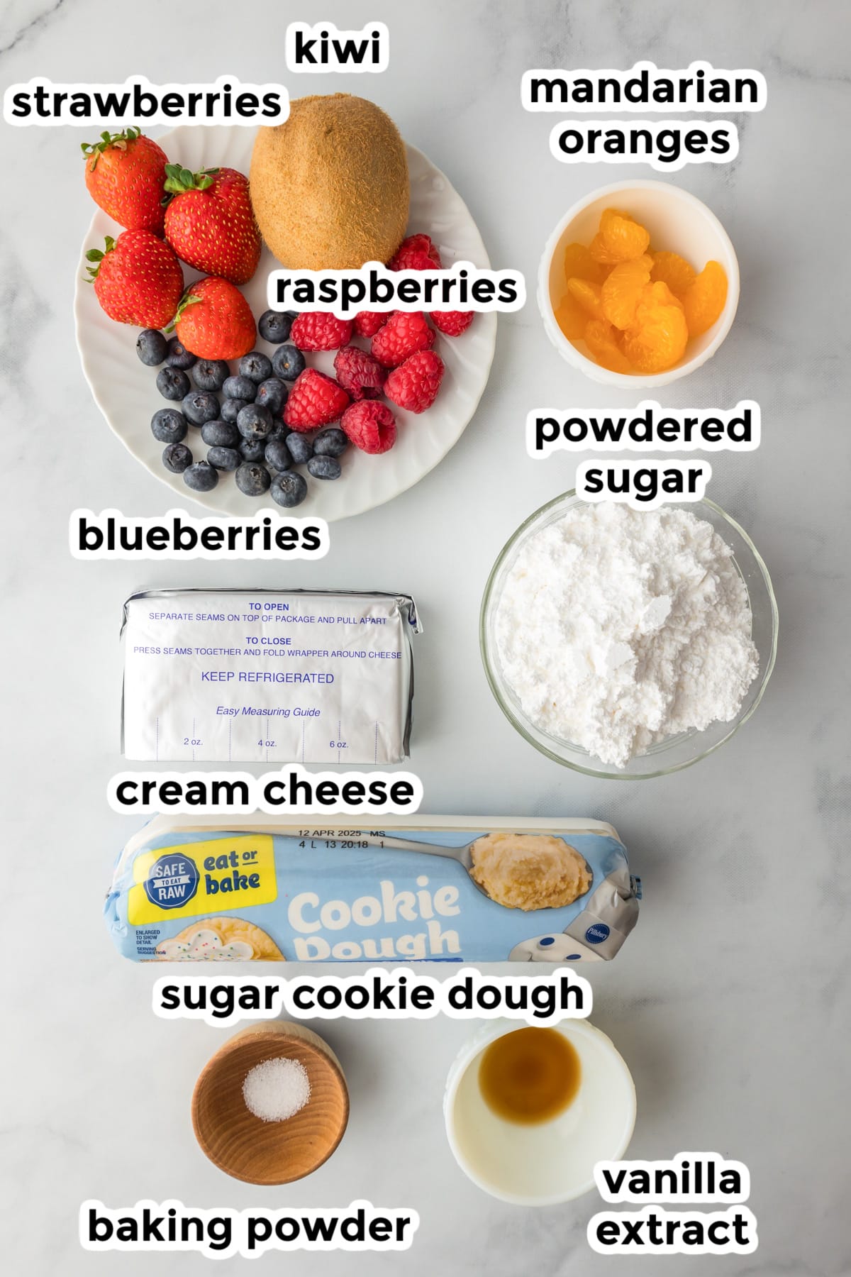 Ingredients for a fruit pizza include strawberries, kiwi, raspberries, mandarin oranges, blueberries, powdered sugar, cream cheese, sugar cookie dough, baking powder, and vanilla extract.