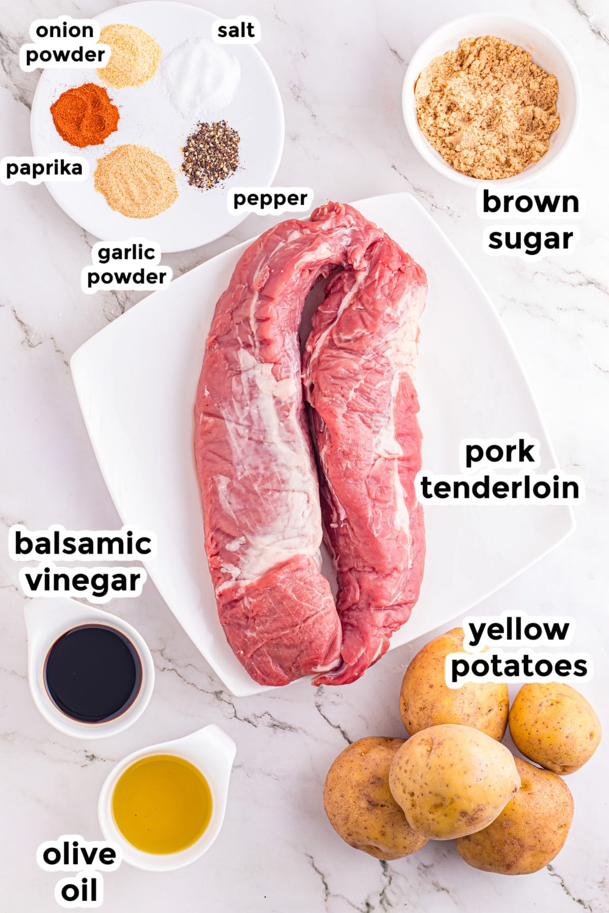 Raw pork tenderloin and raw yellow potatoes on plates on a counter surrounded by other ingredients in bowls for pork tenderloin and potatoes.