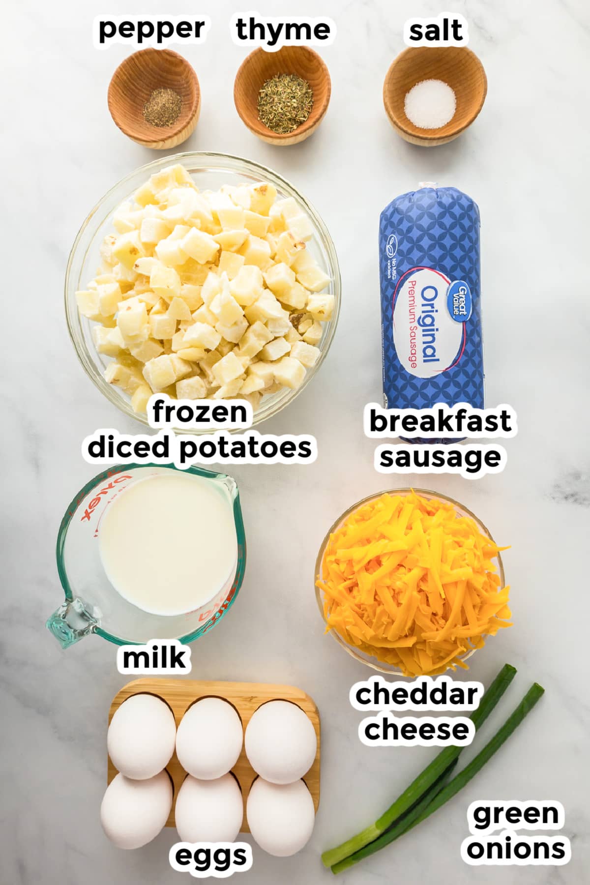 Ingredients for sausage potato breakfast casserole on a counter in bowls with text labels.