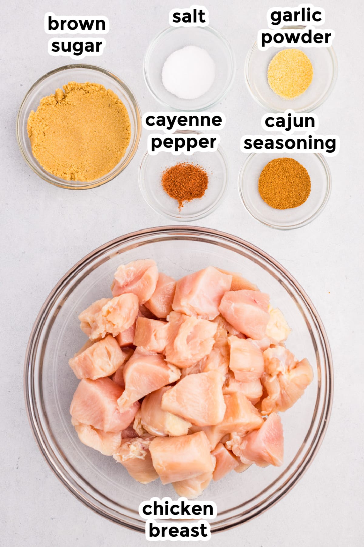 Ingredients for air fryer chicken bites on a counter in bowls with text labels.