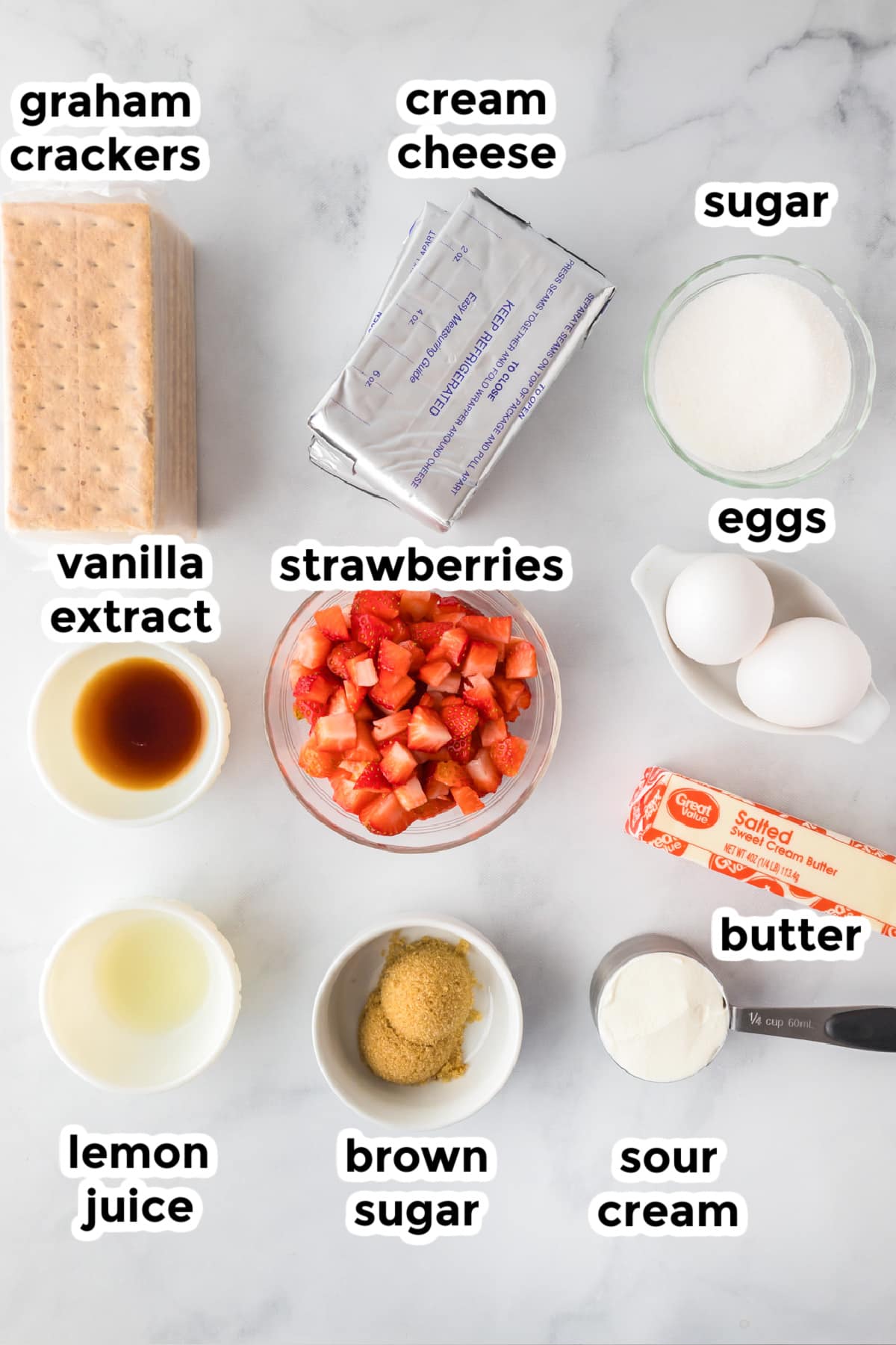 Ingredients for strawberry cheesecake bars in bowls on a counter with text labels.