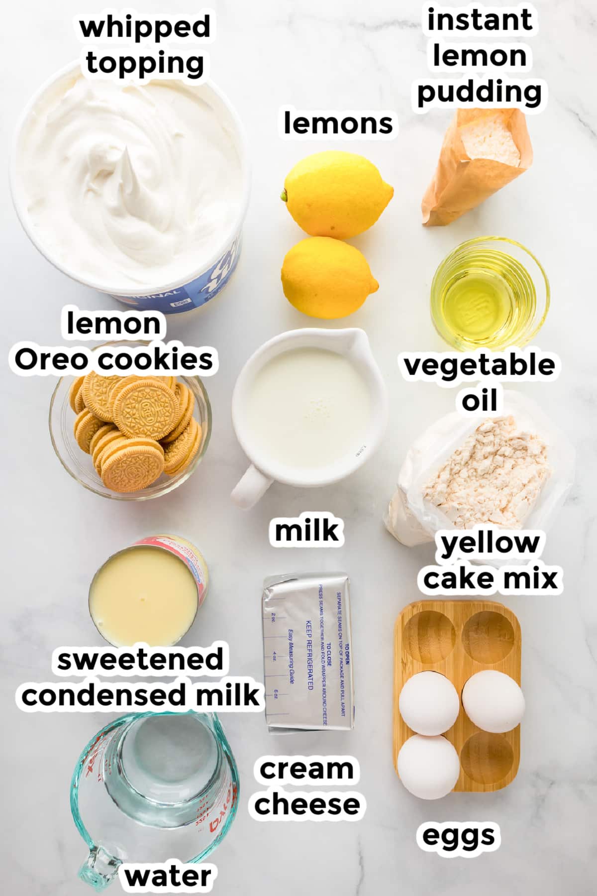 Ingredients for lemon poke cake from overhead with text labels.