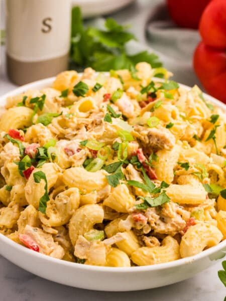 Square verison of a white bowl filled with creamy chicken macaroni pasta salad.