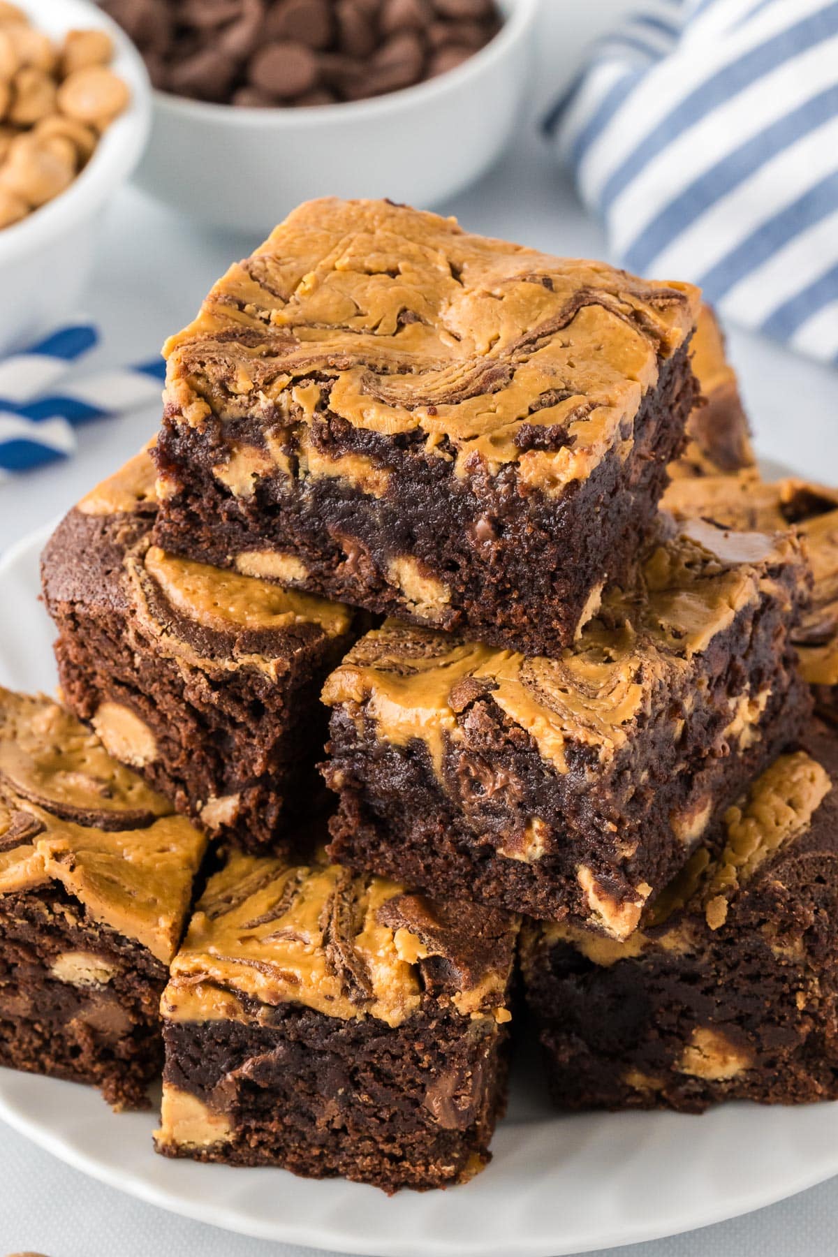 A serving plate stacked high with peanut butter swirled chocolate brownies.