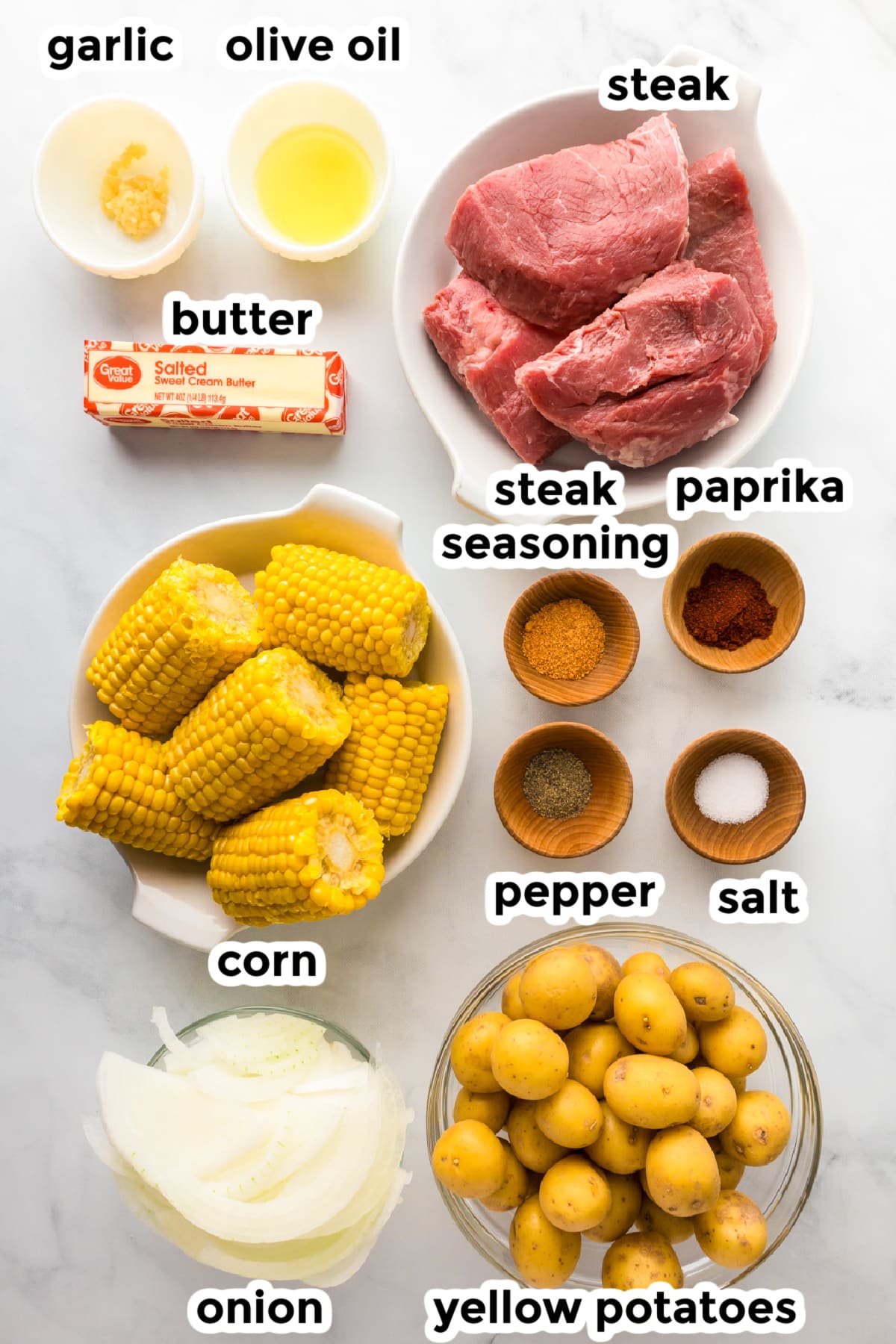 Ingredients for steak and potatoes in the crock pot on a counter with title text labels.