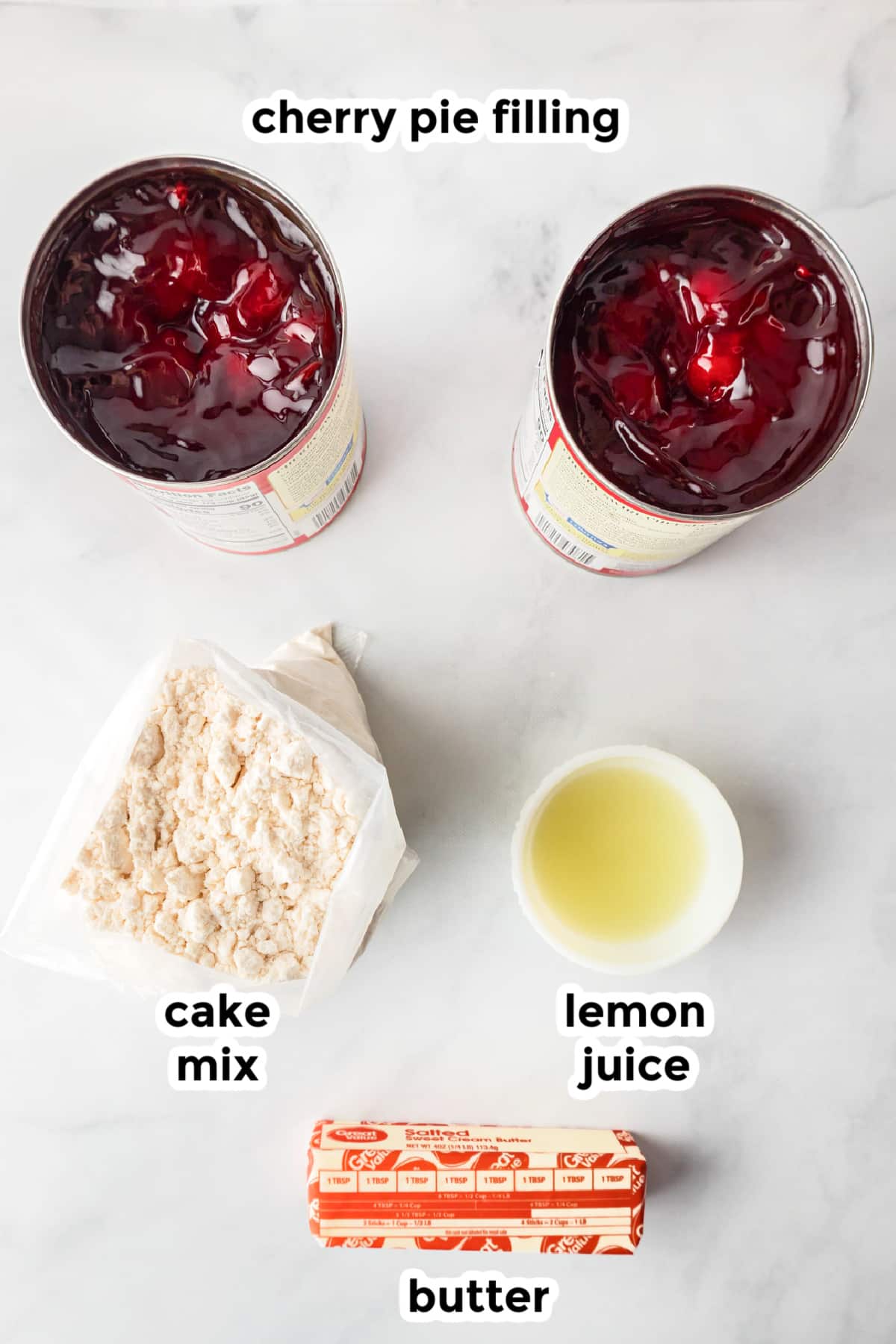 Ingredients for cherry dump cake on a counter with text labels.