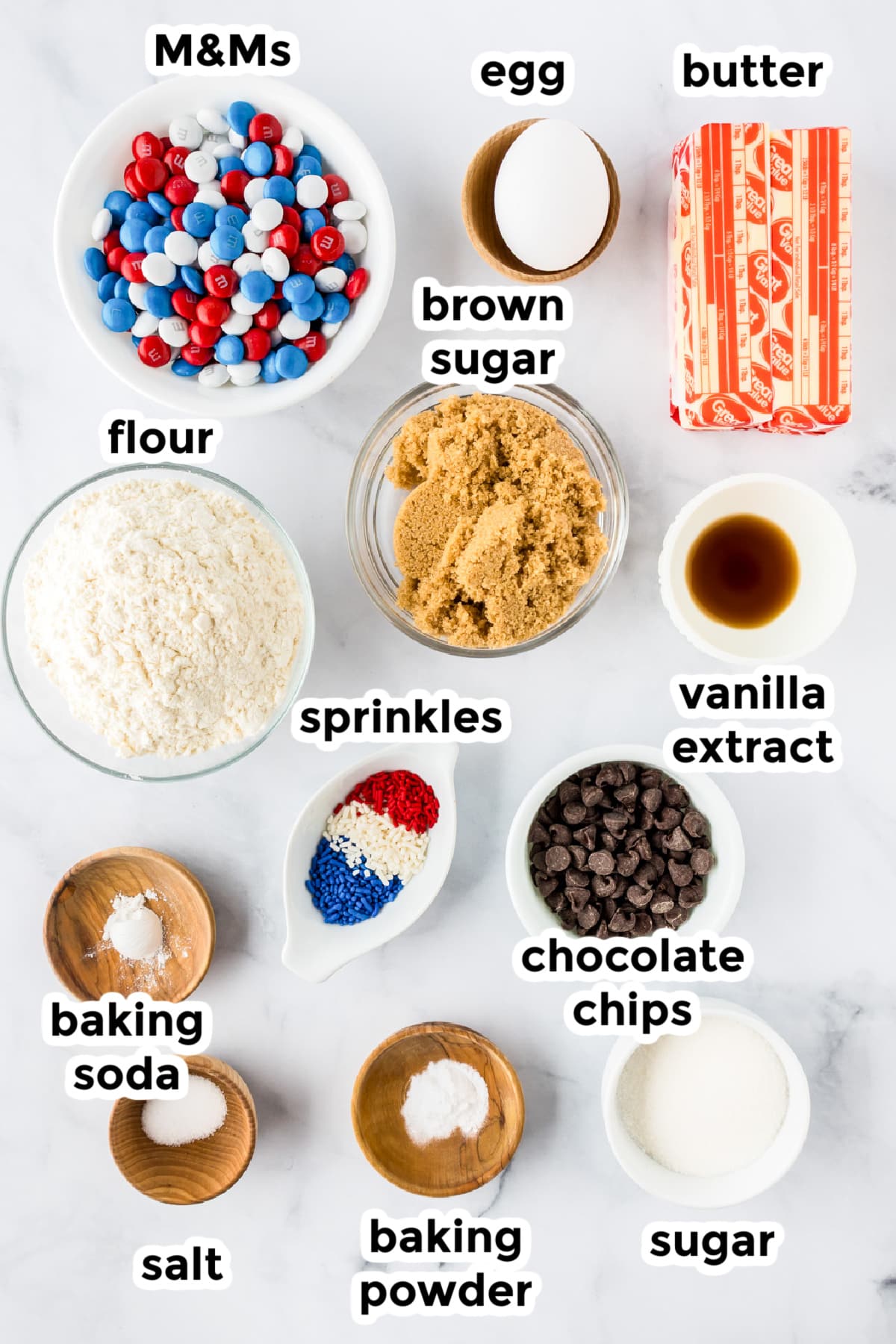Ingredients for red white and blue M&M cookies in bowls with text labels.