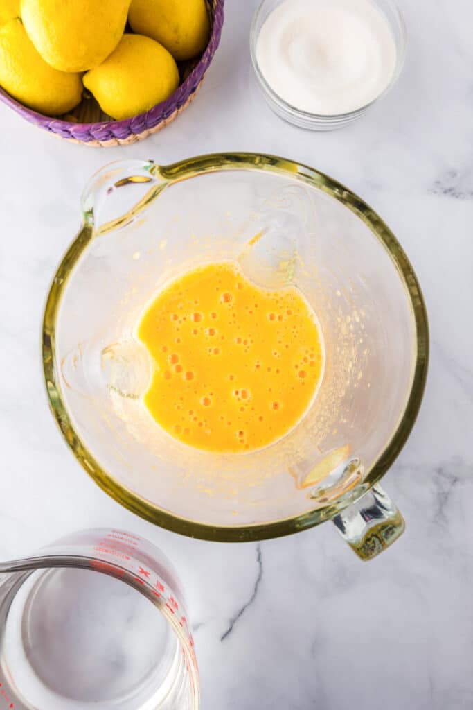 A glass blender base full of blended peach mixture.