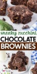 Chocolate brownies with visible zucchini pieces are stacked on a plate and arranged on a table with a glass of milk, chocolate chips, and a fresh zucchini nearby.