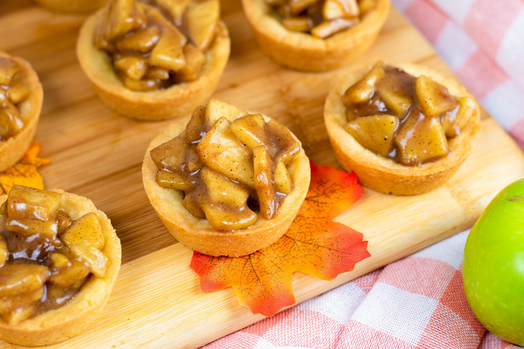Wide view of apple cookie cups served on a cutting board.
