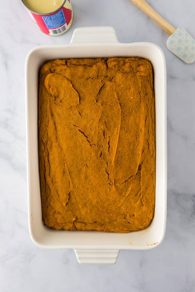 Rectangular baking dish filled with an even layer of baked pumpkin poke.