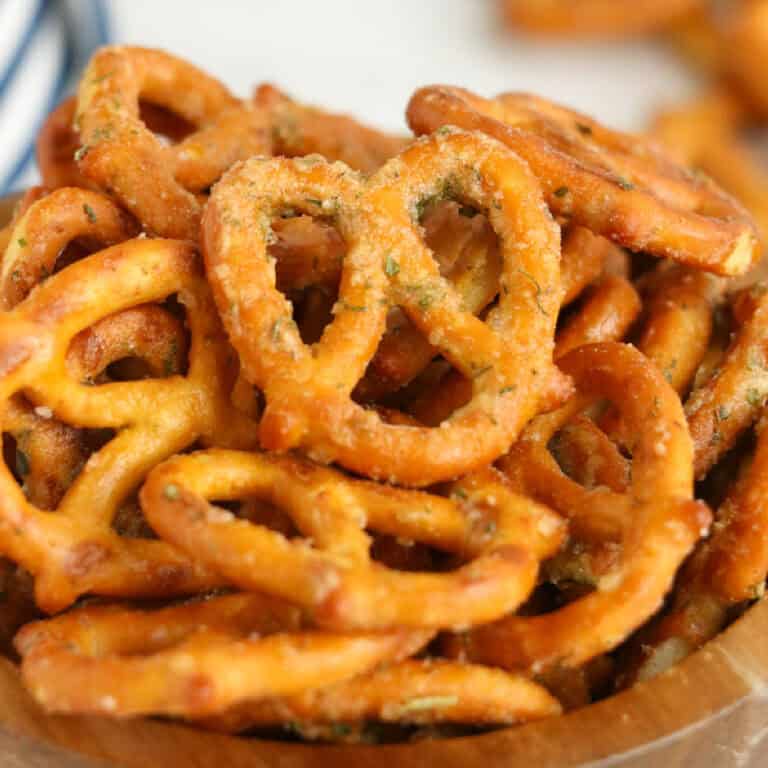 A close-up of a bowl filled with crunchy, seasoned ranch pretzels.