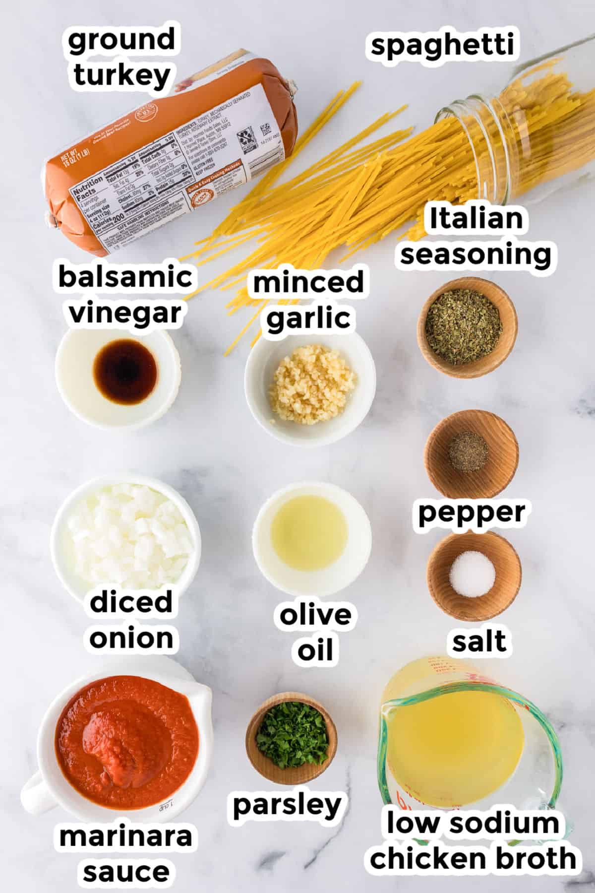 Labeled ingredients for a ground turkey spaghetti dish, including spaghetti, marinara sauce, olive oil, minced garlic, diced onion, parsley, Italian seasoning, balsamic vinegar, salt, pepper, and chicken broth.