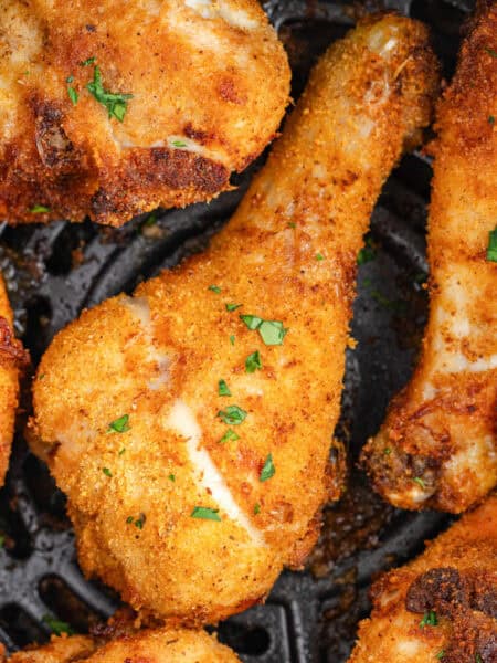 Close-up of crispy shake and bake air fryer chicken drumsticks on an air fryer grate.