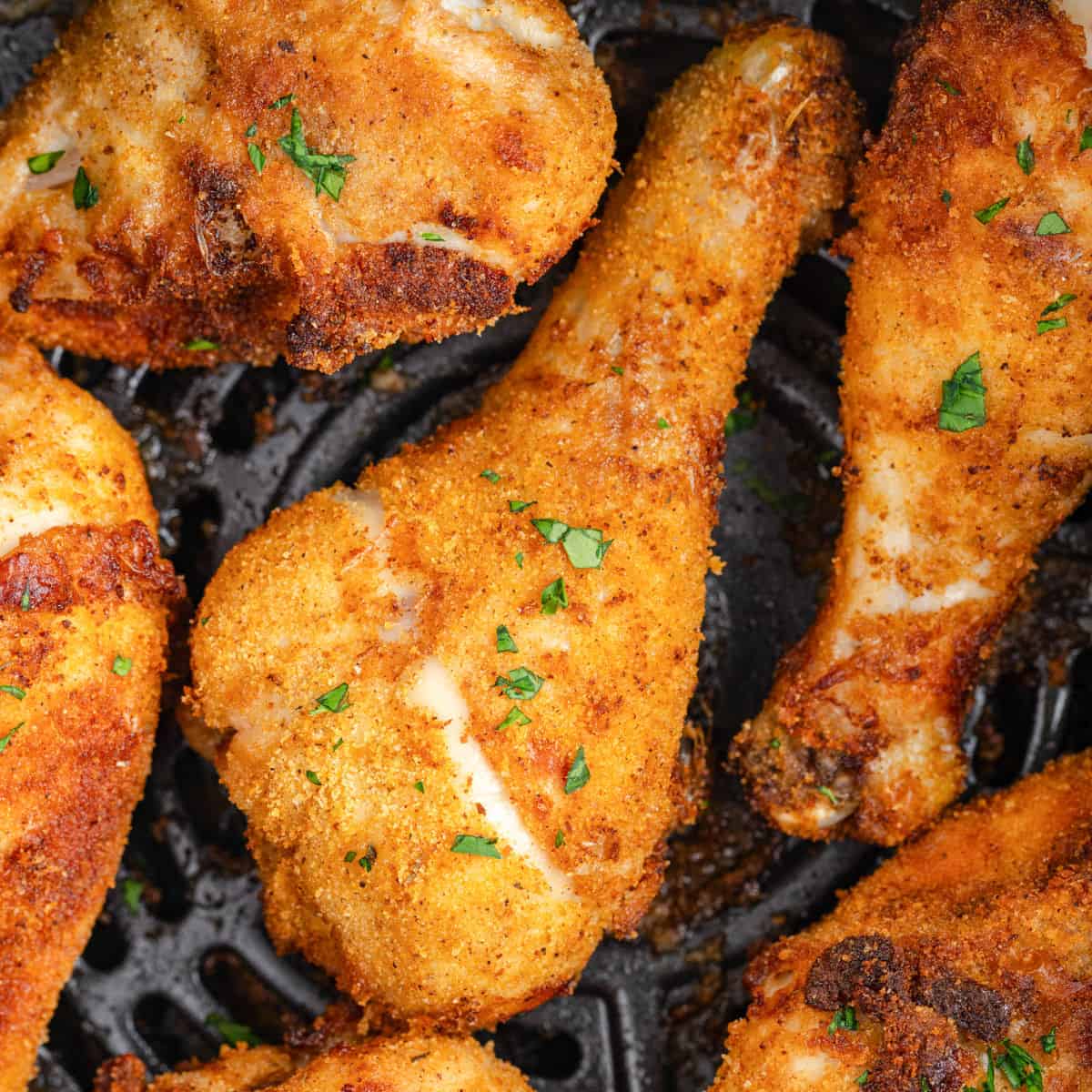 Close-up of crispy shake and bake air fryer chicken drumsticks on an air fryer grate.
