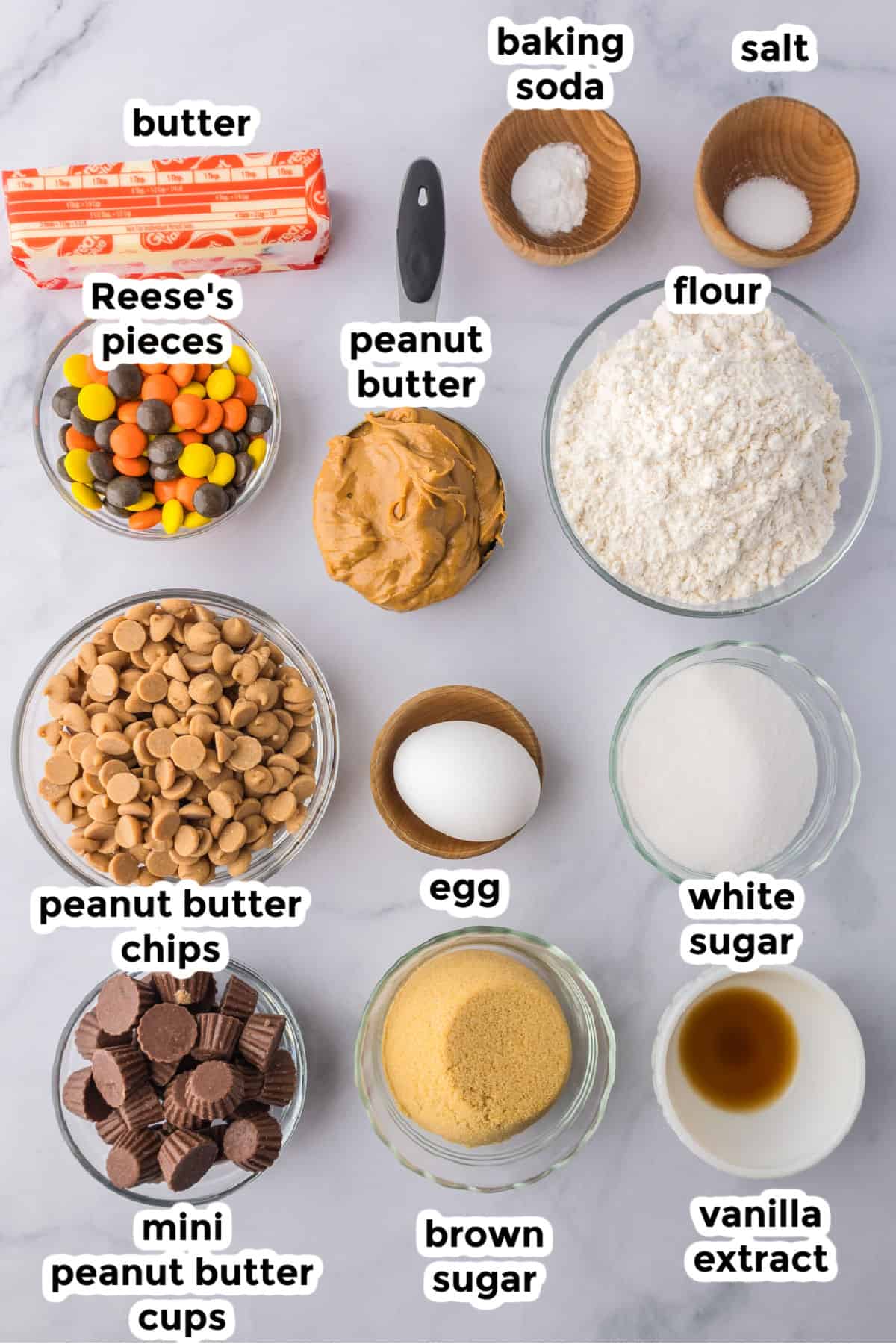 All baking ingredients for Reeses pieces peanut butter cookies on a counter with text labels.