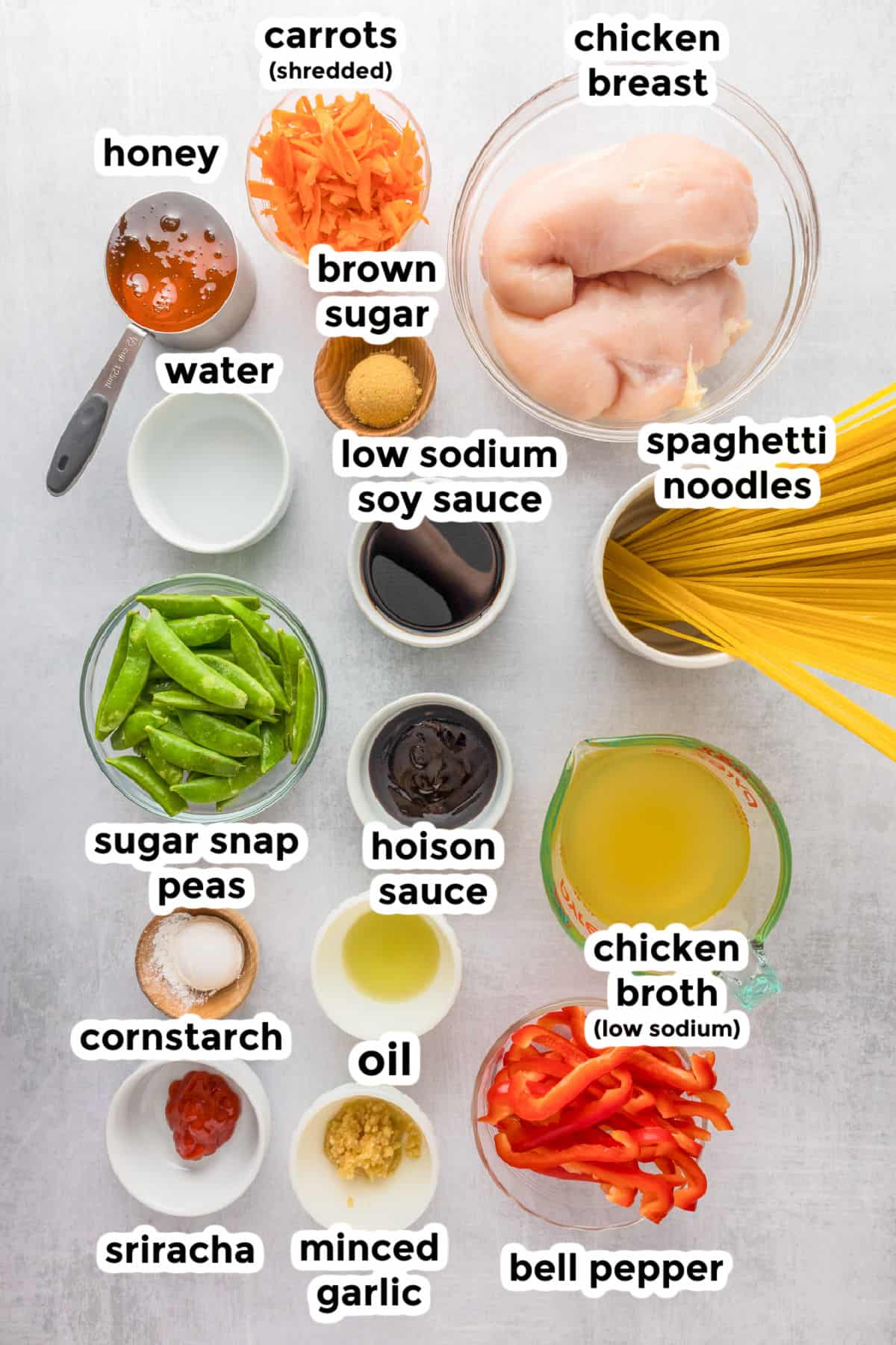 Various labeled ingredients for honey garlic chicken noodles are arranged on a light surface counter.