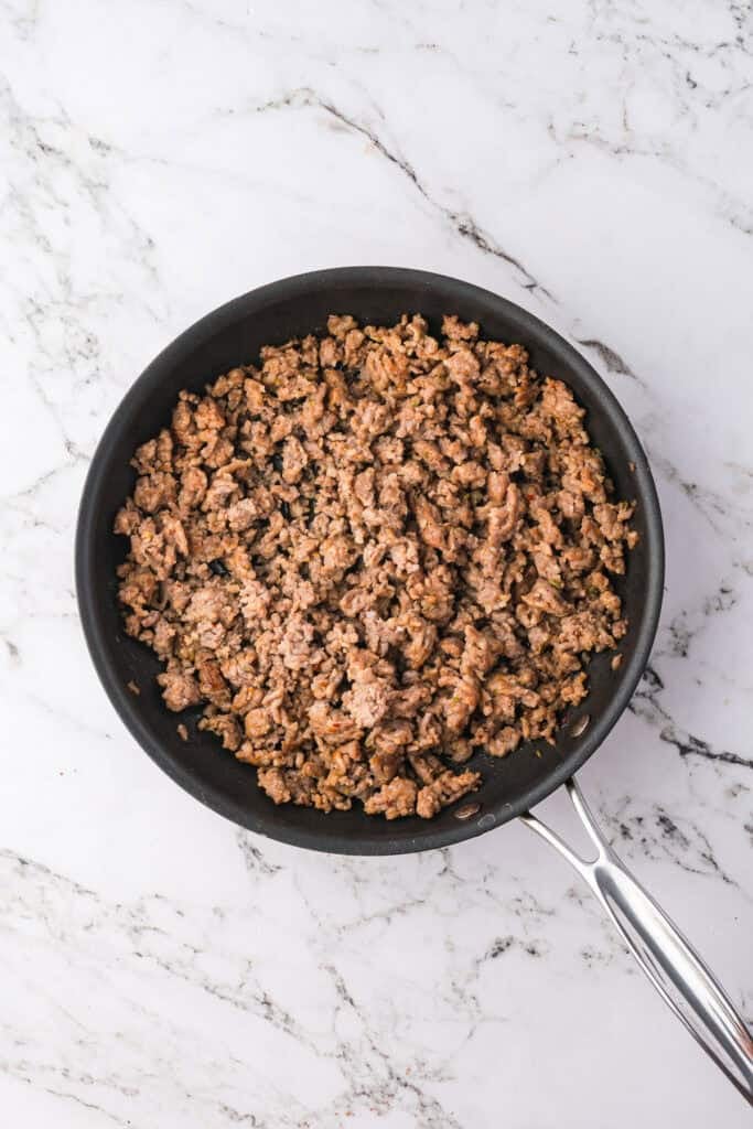 Cooked ground sausage in a skllet for manicotti with sausage.