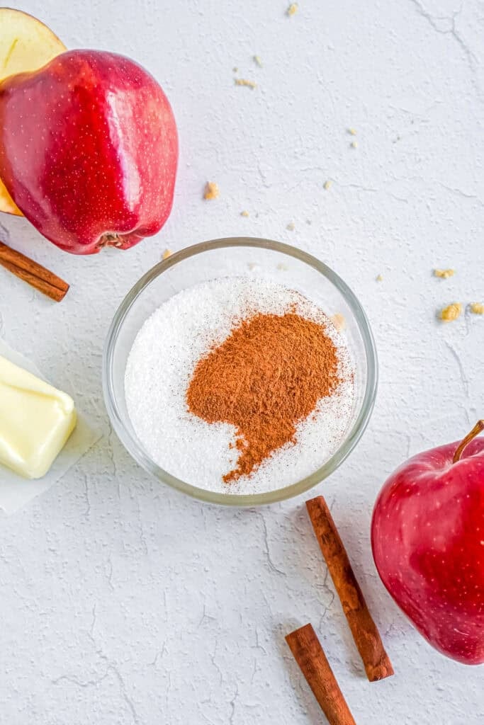 Bowl of sugar being mixed with cinnamon for the apple cider donut cake topping.