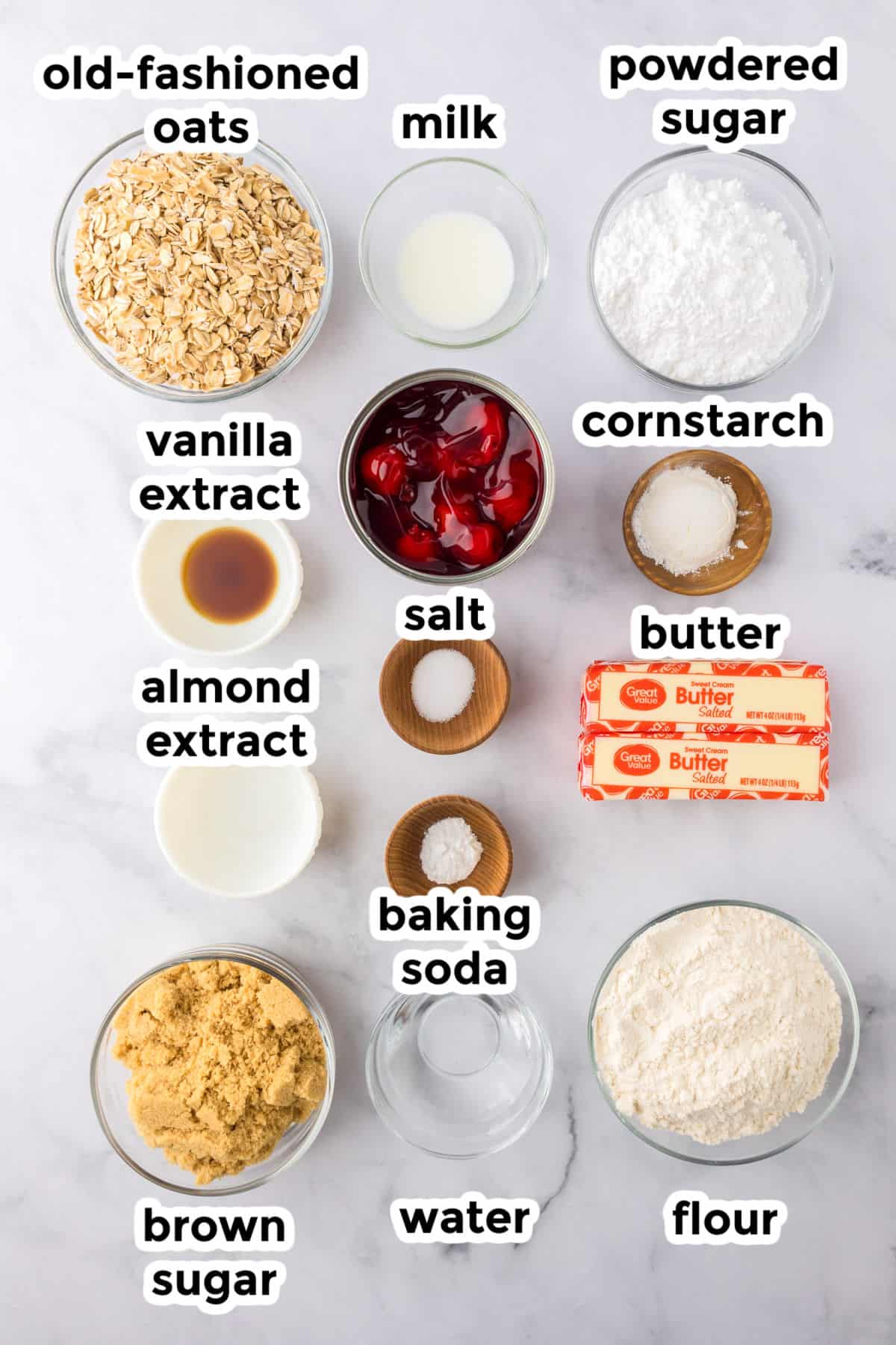 Overhead view of labeled baking ingredients for cherry pie bars in bowls and plates.
