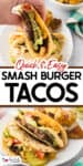 A person holds a smash burger taco filled with beef, lettuce, pickles, and sauce, with more tacos and potato wedges on plates in the background.